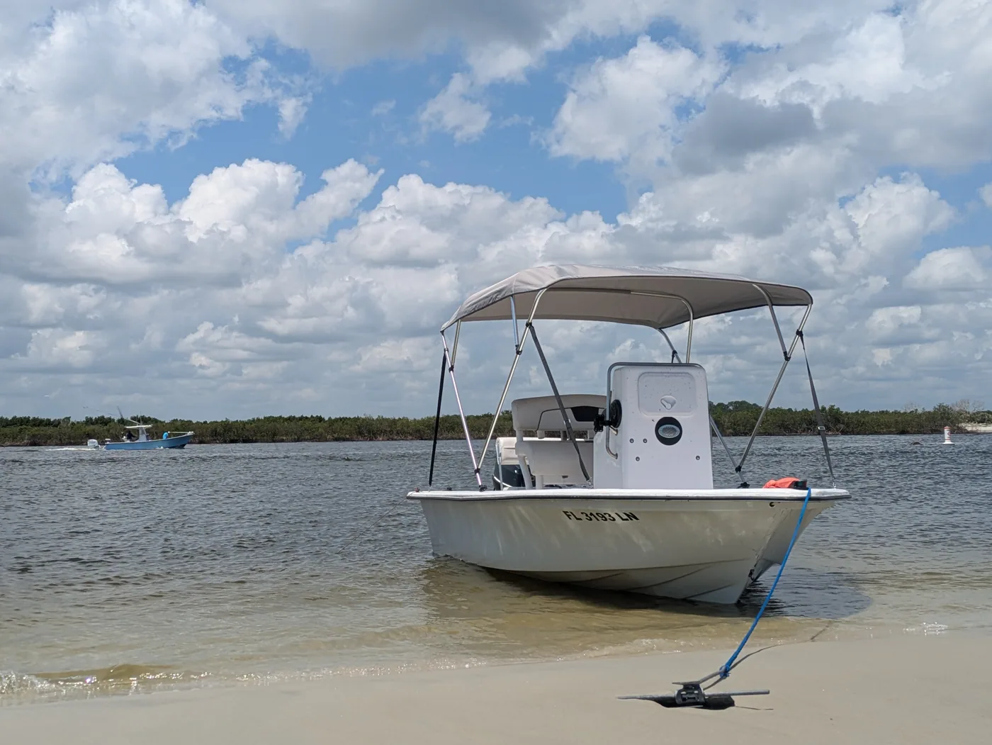 Cody’s boat pulled onto a sandy shoreline under a cloud-filled sky