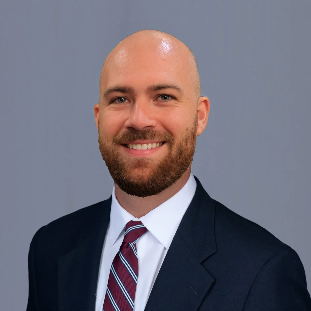 Cody Mitchell smiling in a navy suit