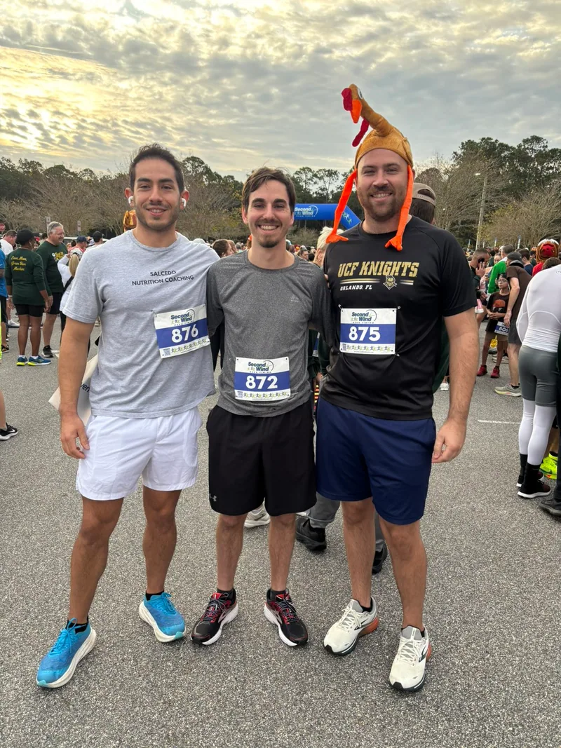 Cody wearing a turkey hat with friends after a community race